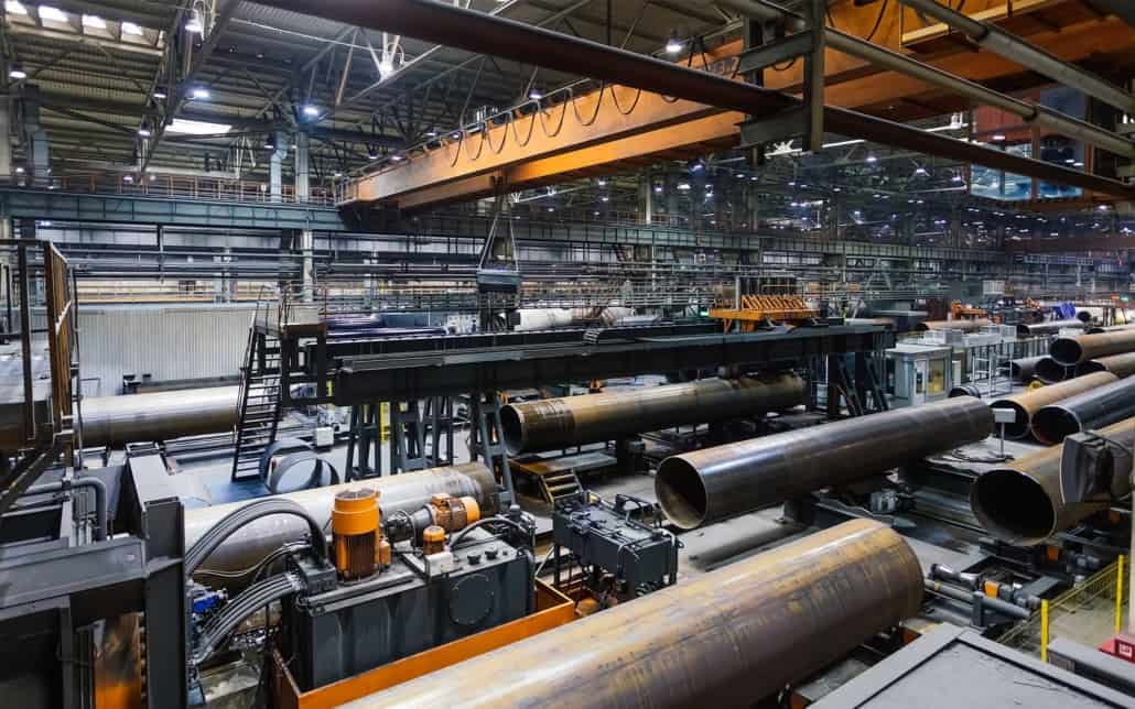 Large industrial facility with oversized metal pipes being constructed
