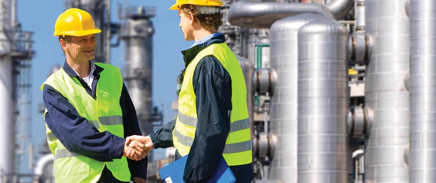 two workers shaking hands at a work plant