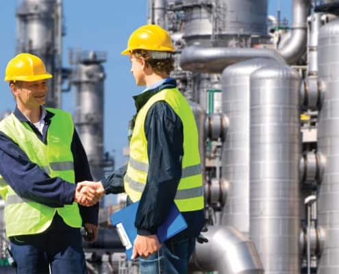 two workers shaking hands at a work plant
