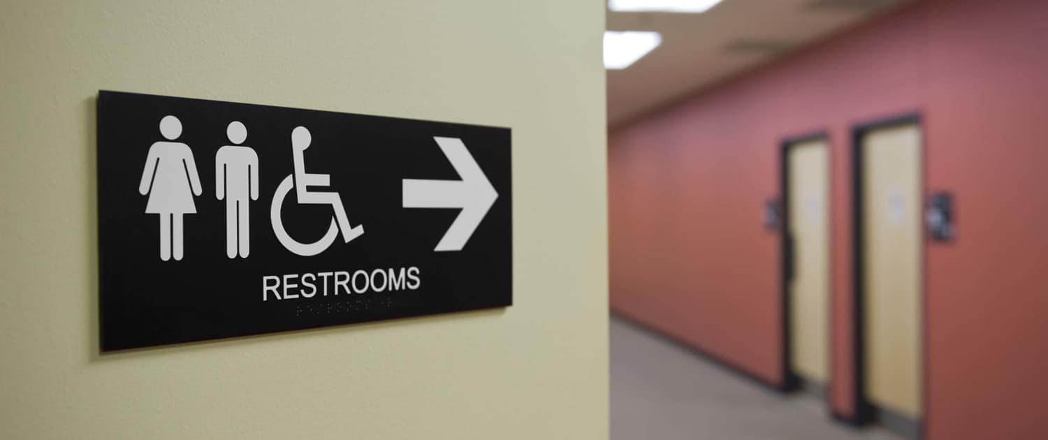 A sign indicating bathrooms are down the hall
