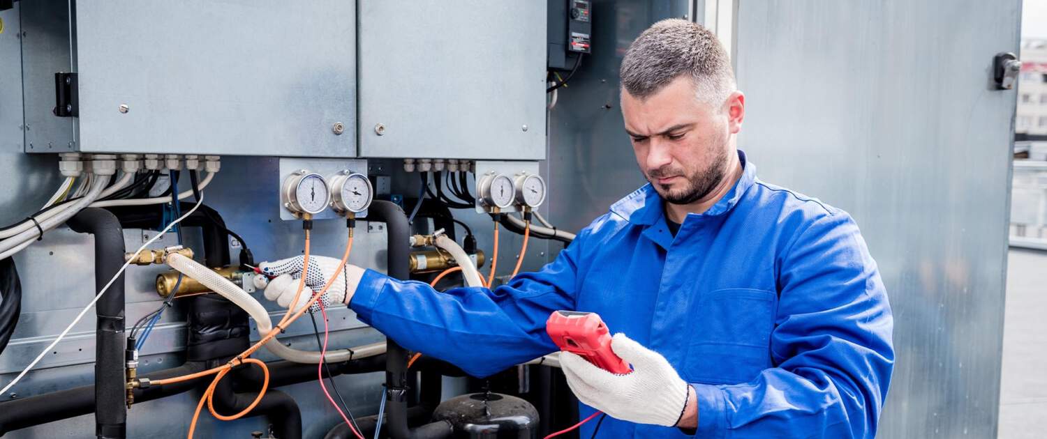 HVAC Worker using tool on cooling machines