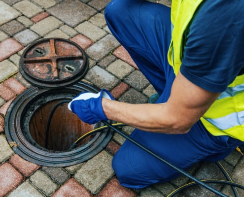 service worker cleaning blocked sewer line with hydro jetting