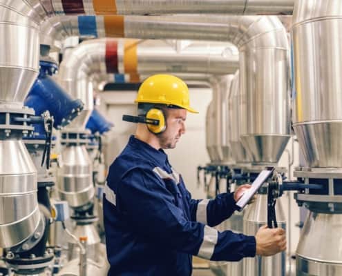 Worker inspecting industrial boiler