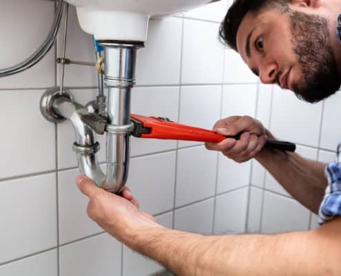Side view of a maintenance man working on plumbing