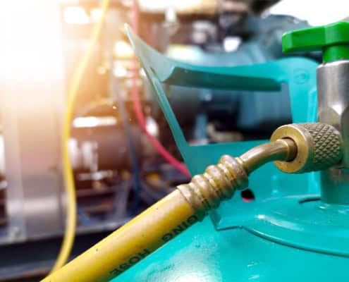 Close up view of refrigerant hooked up to HVAC unit