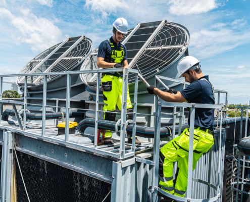 Professional worker servicing HVAC building cooling tower, Industry air conditioner service