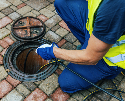 service worker cleaning blocked sewer line with hydro jetting