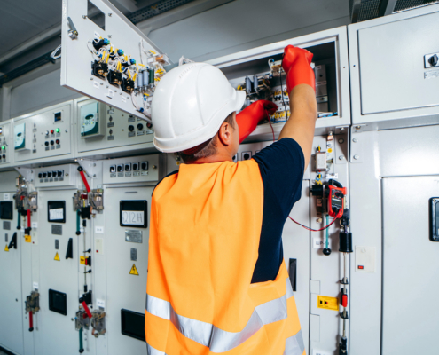 engineer testing and screwing equipment in fuse box