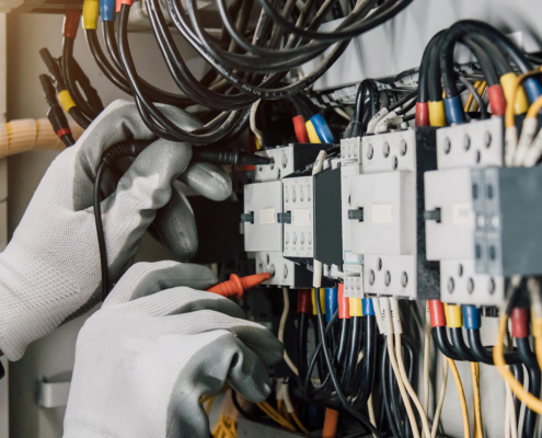 Electrician engineer tests electrical installations and wires on relay protection system