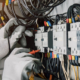 Electrician engineer tests electrical installations and wires on relay protection system