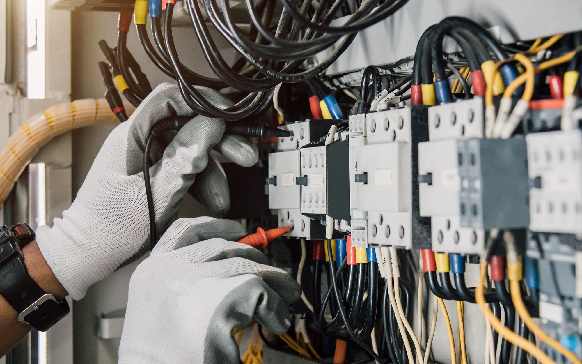 Electrician engineer tests electrical installations and wires on relay protection system